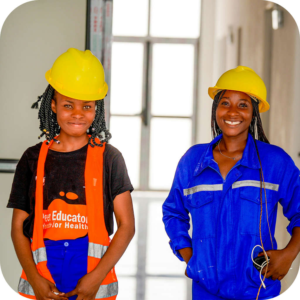 Image of two high school students wearing safety equipment while on a construction site.