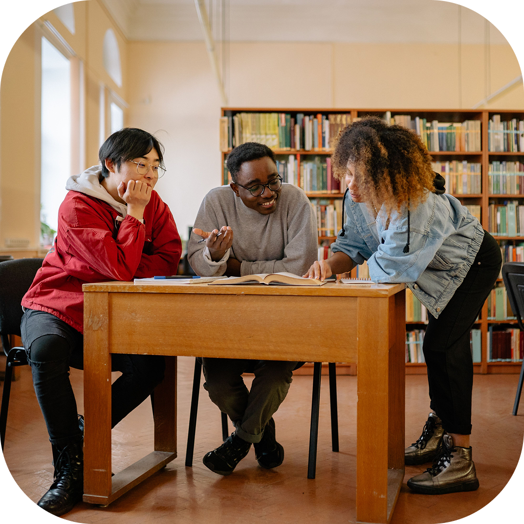 Image of a group of three students collaborating on a project in their school's library..